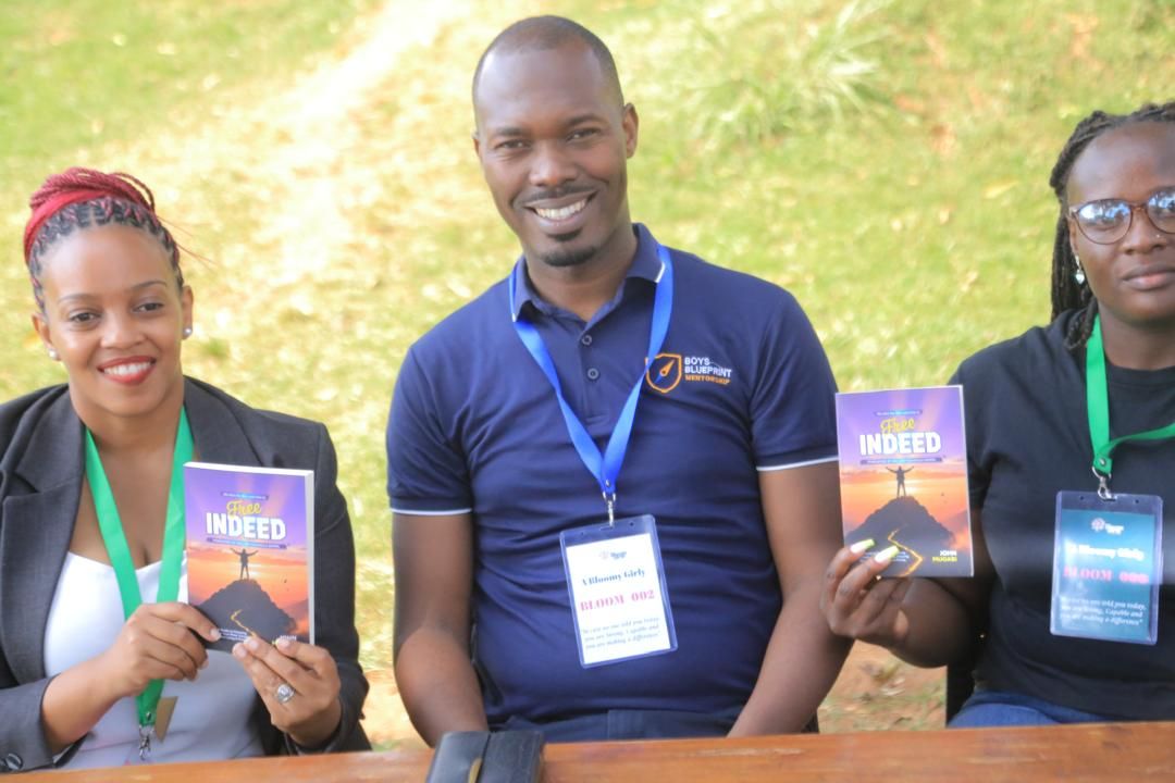 John Mugabi with two young women holding copies of Free Indeed