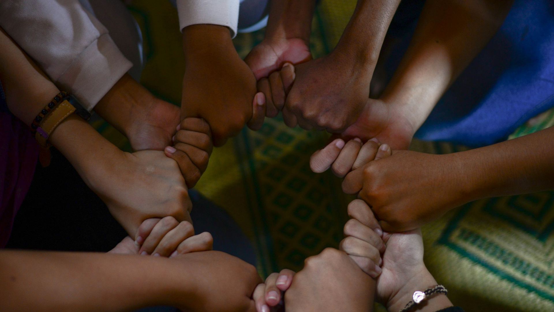 A circle of hands held together in unity