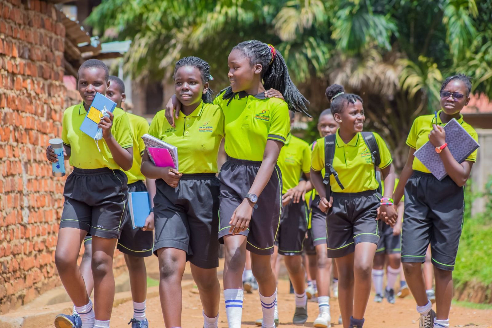 Smiling Ugandan secondary school students walking together in school uniform